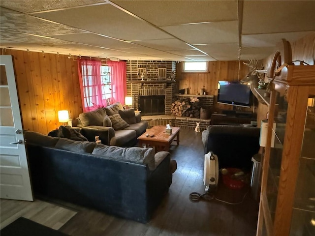 101 26th Avenue Dr SW, Cedar Rapids, IA 52404 - living room with wood walls, wood finished floors, a brick fireplace, and a paneled ceiling