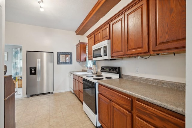 311 3rd St S, Coggon, IA 52218 - kitchen featuring white appliances, a sink, brown cabinetry, light flooring, and baseboards