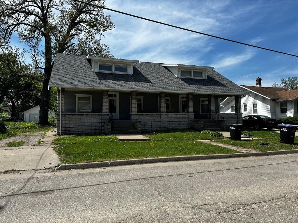 731-733 5th Ave, Marion, IA 52302 - view of front of property featuring a porch, roof with shingles, a front lawn, and stone siding