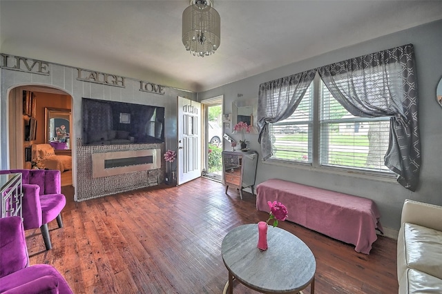 361 30th St SE, Cedar Rapids, IA 52403 - living room featuring arched walkways, wood finished floors, and a glass covered fireplace