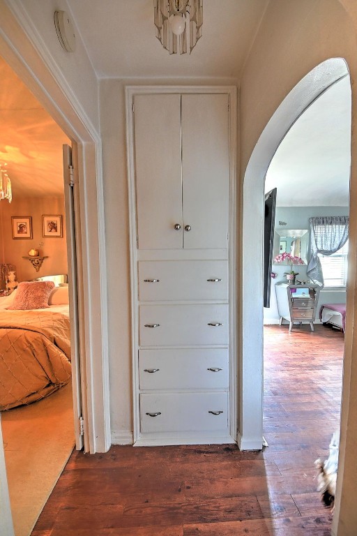 361 30th St SE, Cedar Rapids, IA 52403 - hallway featuring arched walkways, dark wood-style flooring, and a chandelier