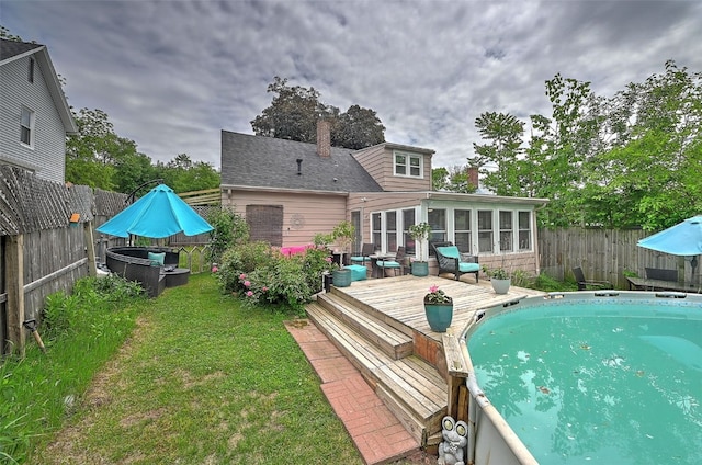 361 30th St SE, Cedar Rapids, IA 52403 - rear view of property with a wooden deck, a sunroom, and a chimney