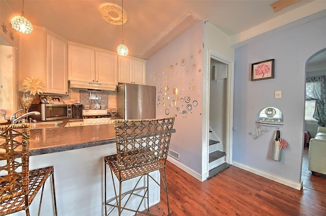361 30th St SE, Cedar Rapids, IA 52403 - kitchen featuring freestanding refrigerator, arched walkways, dark wood-style flooring, and a sink
