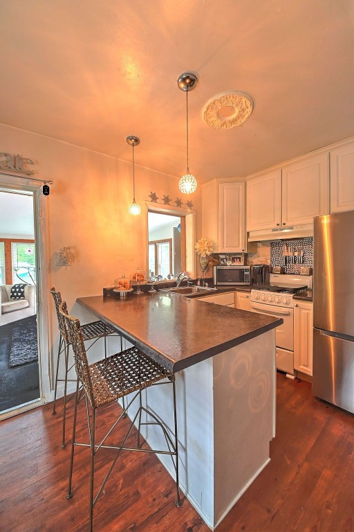 361 30th St SE, Cedar Rapids, IA 52403 - kitchen featuring stainless steel appliances, dark countertops, and white cabinets