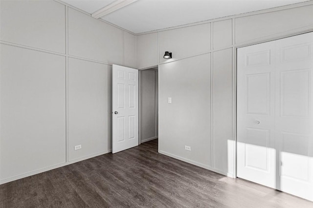 840 S Dubuque St, Solon, IA 52333 - unfurnished bedroom with dark wood-style flooring and baseboards