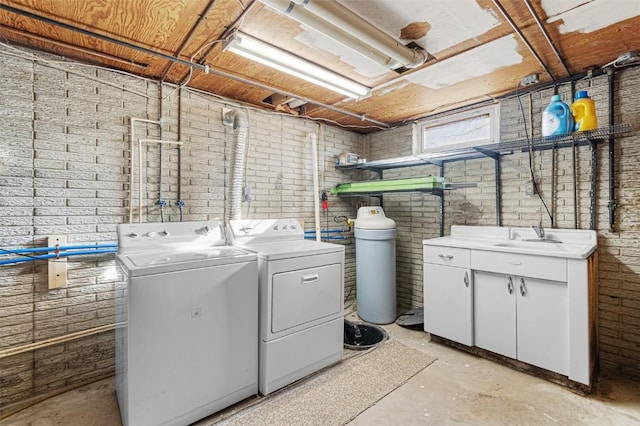 840 S Dubuque St, Solon, IA 52333 - laundry room featuring independent washer and dryer, brick wall, and cabinet space