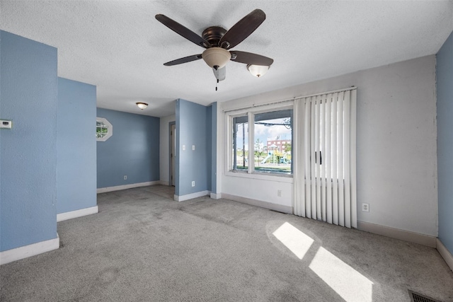 87 14th Ave SW, Cedar Rapids, IA 52404 - carpeted empty room with ceiling fan, a textured ceiling, and baseboards