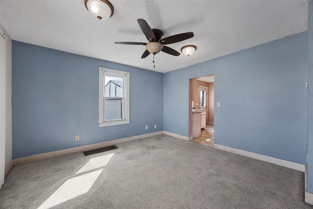 87 14th Ave SW, Cedar Rapids, IA 52404 - unfurnished room featuring a ceiling fan, carpet flooring, a textured ceiling, and baseboards