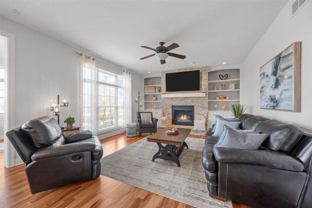 2545 Silver Oak Trl, Marion, IA 52302 - living room featuring wood finished floors, a ceiling fan, a stone fireplace, built in features, and recessed lighting