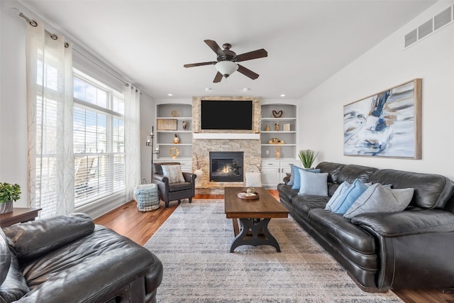 2545 Silver Oak Trl, Marion, IA 52302 - living area featuring ceiling fan, wood finished floors, a fireplace, and built in features