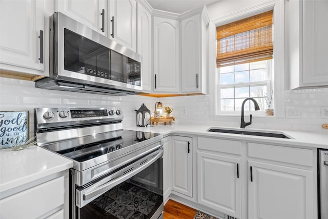 2545 Silver Oak Trl, Marion, IA 52302 - kitchen with stainless steel appliances, a sink, white cabinets, decorative backsplash, and light countertops