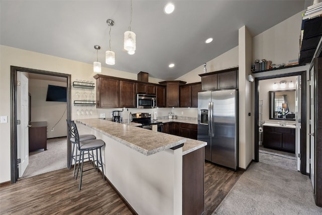 1330 Redbud Ave, Tiffin, IA 52340 - kitchen with stainless steel appliances, dark brown cabinetry, light countertops, dark wood finished floors, and a peninsula