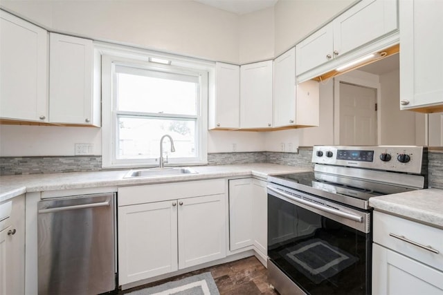 662 19th Ave SW, Cedar Rapids, IA 52404 - kitchen with stainless steel appliances, a sink, white cabinets, light countertops, and dark stone finish flooring
