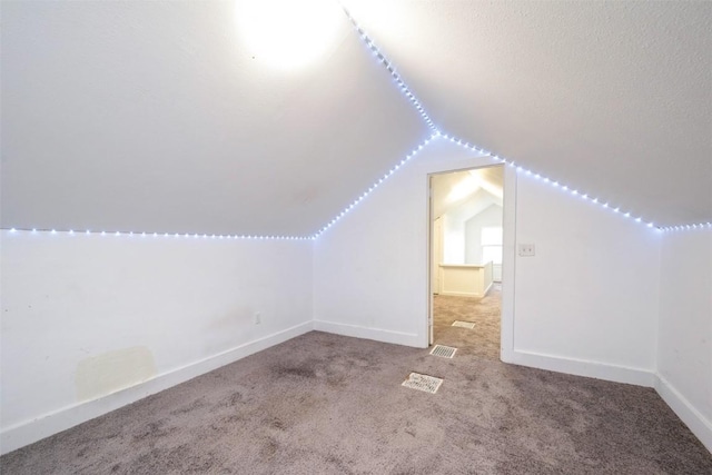 662 19th Ave SW, Cedar Rapids, IA 52404 - additional living space featuring vaulted ceiling, carpet floors, baseboards, and a textured ceiling