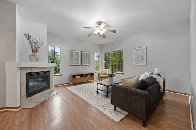 364 Camden Rd, Iowa City, IA 52245 - living room featuring plenty of natural light, a ceiling fan, a tiled fireplace, and wood finished floors