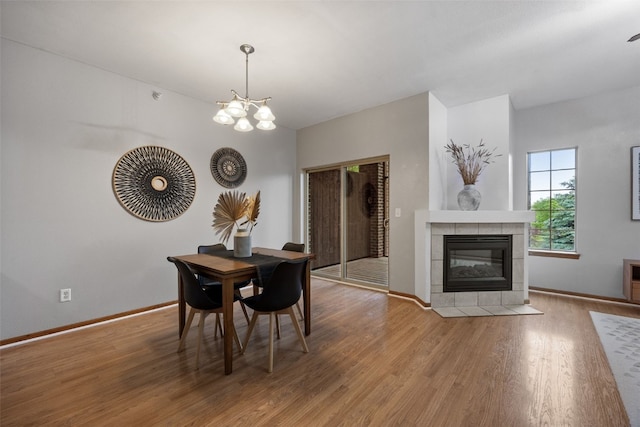 364 Camden Rd, Iowa City, IA 52245 - dining area featuring wood finished floors, a chandelier, baseboards, and a tile fireplace