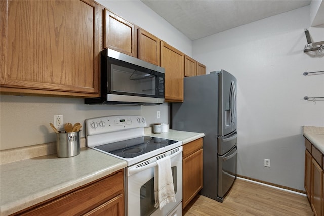 364 Camden Rd, Iowa City, IA 52245 - kitchen featuring appliances with stainless steel finishes, brown cabinets, light wood-type flooring, light countertops, and baseboards