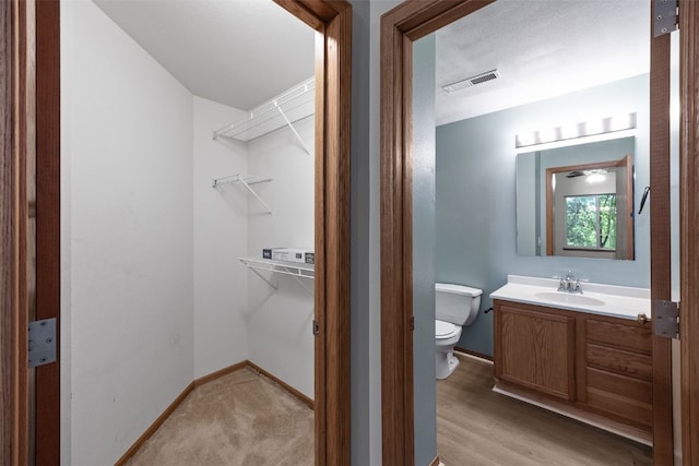 364 Camden Rd, Iowa City, IA 52245 - bathroom featuring vanity, toilet, a walk in closet, and baseboards