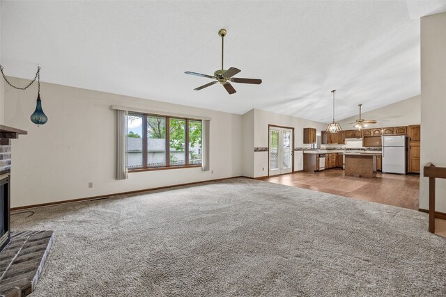 1042 Arthur Dr NW, Cedar Rapids, IA 52405 - unfurnished living room featuring a ceiling fan, lofted ceiling, a fireplace, and light colored carpet