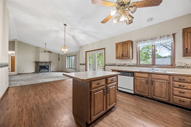 1042 Arthur Dr NW, Cedar Rapids, IA 52405 - kitchen featuring ceiling fan, a brick fireplace, light countertops, light wood-style flooring, and plenty of natural light