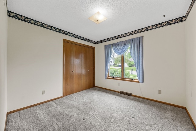 1042 Arthur Dr NW, Cedar Rapids, IA 52405 - unfurnished bedroom with carpet flooring, a closet, and a textured ceiling