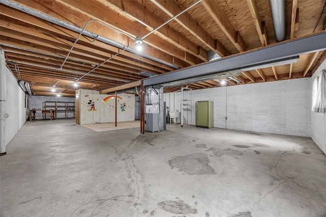 1042 Arthur Dr NW, Cedar Rapids, IA 52405 - unfinished basement with heating unit, brick wall, and fridge