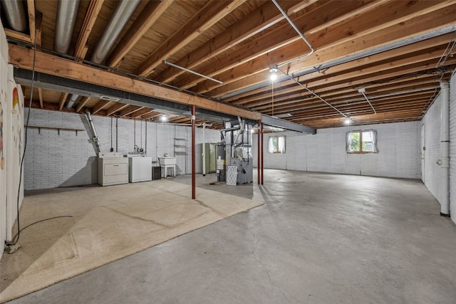1042 Arthur Dr NW, Cedar Rapids, IA 52405 - basement featuring independent washer and dryer, brick wall, heating unit, and water heater