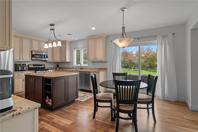 4000 Majestic Ct NE, Cedar Rapids, IA 52411 - kitchen with stainless steel appliances, cream cabinets, light wood-type flooring, light stone counters, and recessed lighting