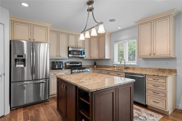 4000 Majestic Ct NE, Cedar Rapids, IA 52411 - kitchen with appliances with stainless steel finishes, cream cabinets, a sink, light stone counters, and pendant lighting