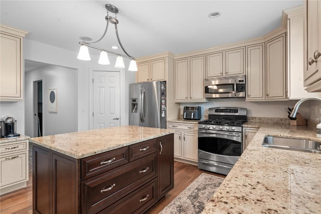 4000 Majestic Ct NE, Cedar Rapids, IA 52411 - kitchen featuring appliances with stainless steel finishes, cream cabinets, a sink, dark brown cabinets, and wood finished floors