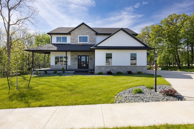 1504 Legend Dr, Tiffin, IA 52340 - view of front of home with stone siding, a front yard, a porch, and a shingled roof
