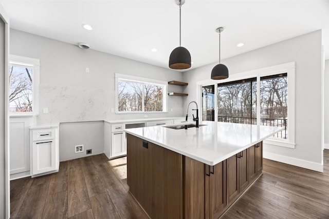 1504 Legend Dr, Tiffin, IA 52340 - kitchen featuring a sink, light countertops, dark wood-type flooring, a center island with sink, and recessed lighting