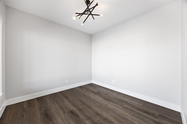 1504 Legend Dr, Tiffin, IA 52340 - unfurnished room with a chandelier, dark wood-type flooring, and baseboards