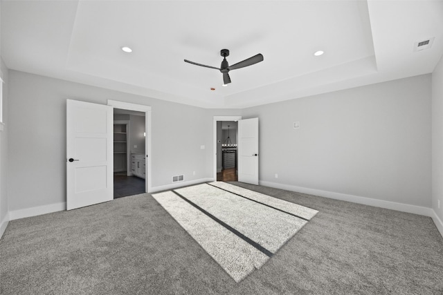1504 Legend Dr, Tiffin, IA 52340 - unfurnished bedroom featuring a raised ceiling, carpet flooring, baseboards, recessed lighting, and ensuite bathroom