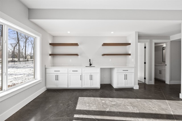 1504 Legend Dr, Tiffin, IA 52340 - unfurnished living room with bar with sink, plenty of natural light, baseboards, finished concrete floors, and recessed lighting