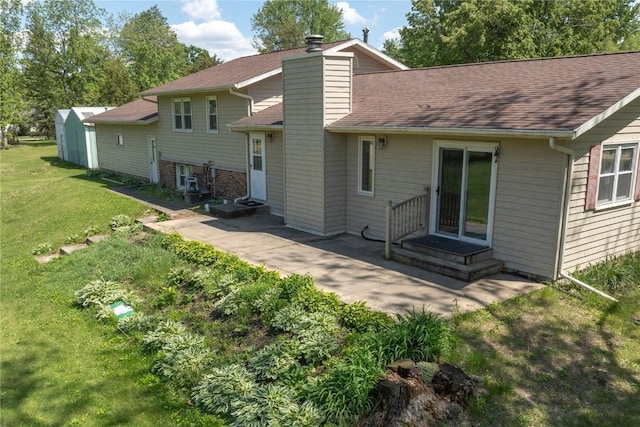 409 Oak St, Rowley, IA 52329 - rear view of house featuring a yard, roof with shingles, and a chimney