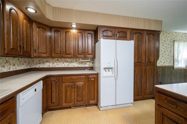 409 Oak St, Rowley, IA 52329 - kitchen featuring white appliances, wallpapered walls, and light countertops
