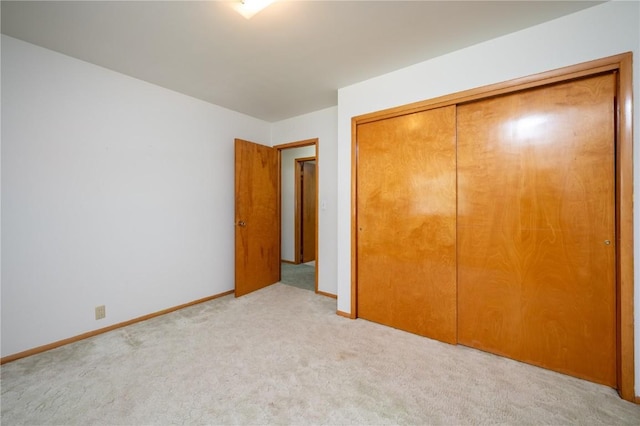 409 Oak St, Rowley, IA 52329 - unfurnished bedroom featuring carpet, a closet, and baseboards