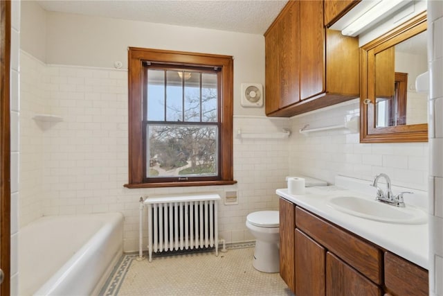 2325 Grande Ave SE, Cedar Rapids, IA 52403 - full bathroom featuring radiator, tile walls, toilet, vanity, and a tub