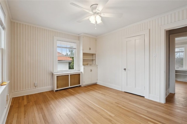 2325 Grande Ave SE, Cedar Rapids, IA 52403 - unfurnished bedroom with radiator, ornamental molding, light wood finished floors, wallpapered walls, and baseboards