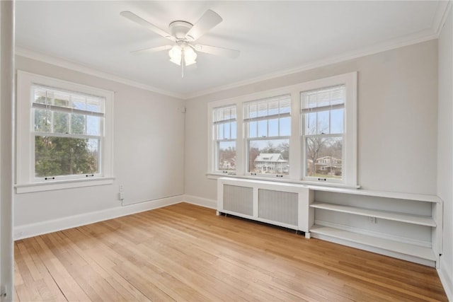 2325 Grande Ave SE, Cedar Rapids, IA 52403 - spare room with radiator, light wood-style floors, ornamental molding, ceiling fan, and baseboards