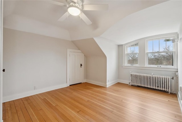 2325 Grande Ave SE, Cedar Rapids, IA 52403 - additional living space featuring radiator heating unit, light wood-type flooring, vaulted ceiling, a ceiling fan, and baseboards