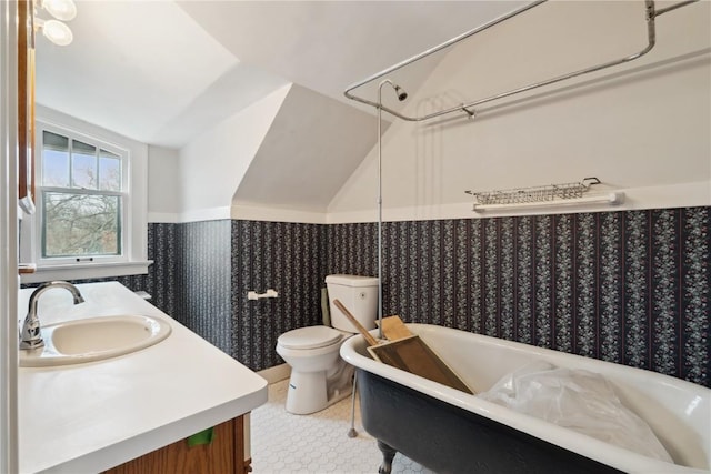 2325 Grande Ave SE, Cedar Rapids, IA 52403 - full bathroom with vanity, a wainscoted wall, lofted ceiling, wallpapered walls, and toilet