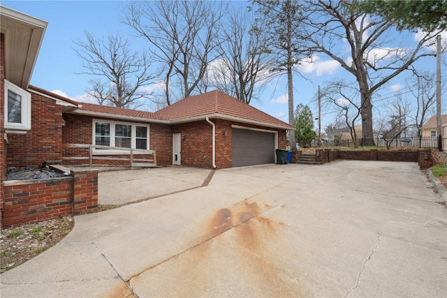2325 Grande Ave SE, Cedar Rapids, IA 52403 - view of home's exterior with an attached garage, brick siding, driveway, and a tile roof