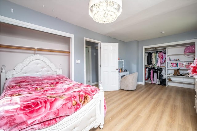 4721 Midway Dr NW, Cedar Rapids, IA 52405 - bedroom featuring wood finished floors, a chandelier, lofted ceiling, and a closet