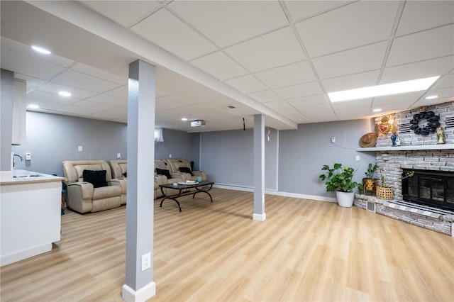 4721 Midway Dr NW, Cedar Rapids, IA 52405 - living area with wood finished floors, a drop ceiling, and a brick fireplace