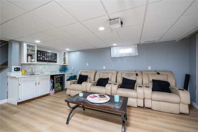 4721 Midway Dr NW, Cedar Rapids, IA 52405 - living room featuring wet bar, light wood-style flooring, wine cooler, a paneled ceiling, and recessed lighting