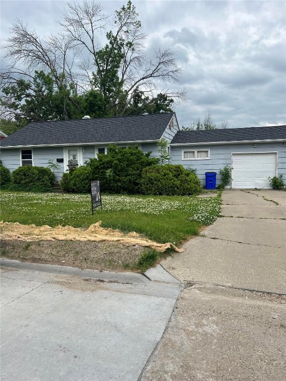 609 37th St NE, Cedar Rapids, IA 52402 - view of front facade featuring driveway, an attached garage, and a front yard