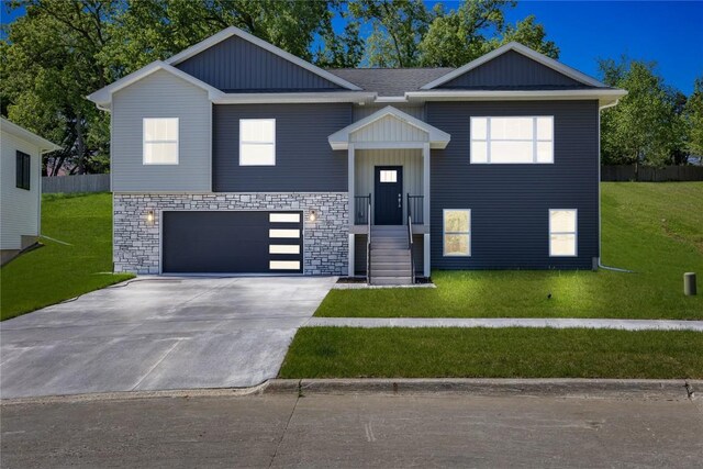 706 Silver Ln, Iowa City, IA 52245 - bi-level home with a front yard, driveway, an attached garage, and stone siding