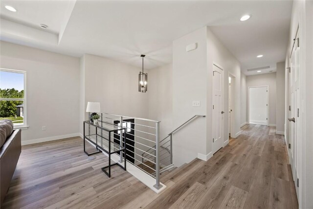 706 Silver Ln, Iowa City, IA 52245 - corridor with an upstairs landing, light wood-style flooring, baseboards, recessed lighting, and a chandelier